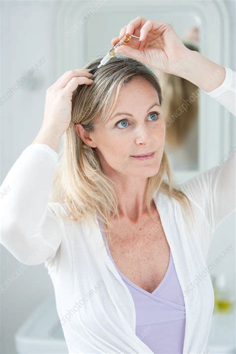 Woman applying hair lotion - Stock Image - C032/7098 - Science Photo ...