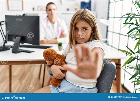 Blonde Kleine Frau in Der Kinderklinik Mit Ärztin Mit Offener Hand Und Stoppschild Mit