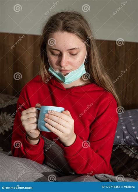 Sick Teen Girl in Facial Mask Drinking Tea in Bed at Home Stock Image