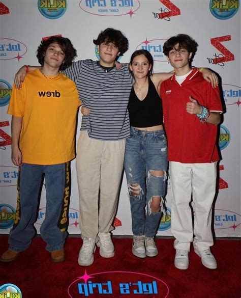 Three Young People Posing For A Photo On The Red Carpet With One Person