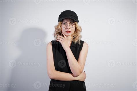 Studio Portrait Of Blonde Girl In Black Wear And Cap Against White Background 10339267 Stock