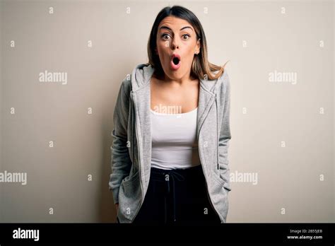 Jeune sportif brunette portant une formation sportive sur fond blanc peur et choqué par l