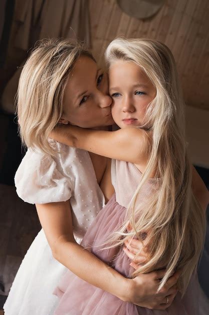 Premium Photo Mother And Daughter Blonde With Long Hair Hug And Kiss