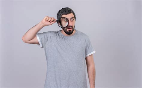 Impresionado joven apuesto hombre caucásico sosteniendo y mirando