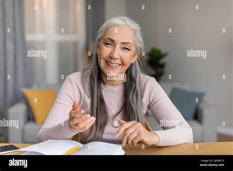 Glad Smiling European Mature Female Teacher With Gray Hair Have Meeting And Looks At Camera In