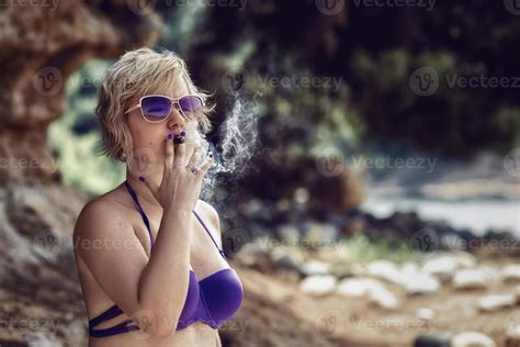 Blonde Woman Smoking A Cigar Blonde Woman In Bikini Smoking A Cigar At The Beach Stock