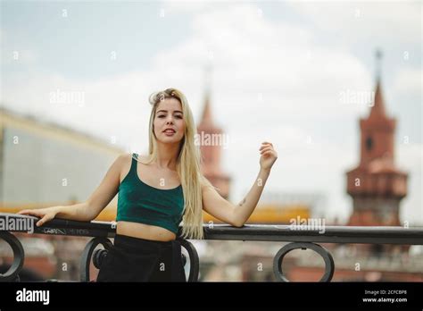 Beautiful Blonde Female Model Leaning On Railing On Summer Day In