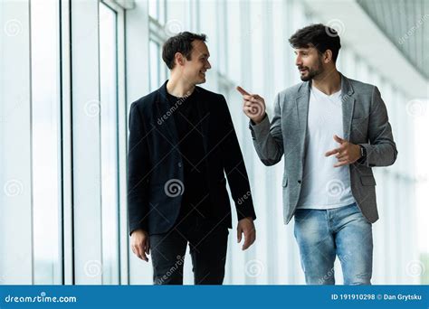 Two Businessmen Discussing Project At Meeting At Office Business