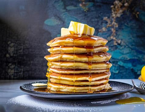 Premium AI Image | The tall stack of huge fluffy pancakes covered in ...