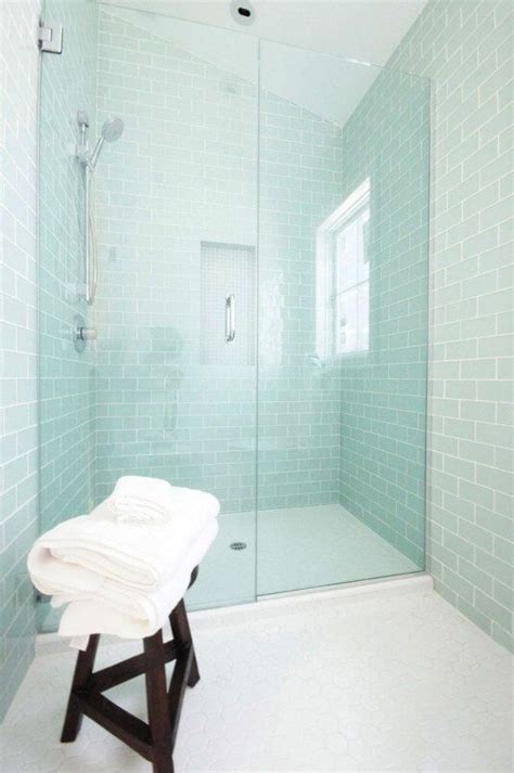 A White Towel Sitting On Top Of A Bath Tub Next To A Walk In Shower