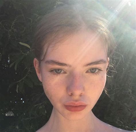 A Young Woman With Freckled Hair And Blue Eyes Is Posing For The Camera