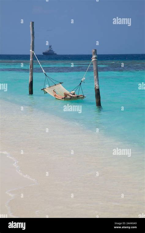 Frau im Bikini und einem Hut Relaxen in der Hängematte im Meer an der Insel Bandos Malediven