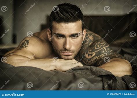 Shirtless Male Model Lying Alone On His Bed Coloso