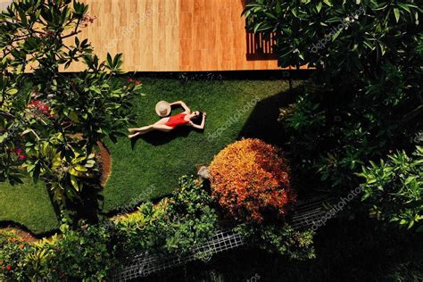 Hermosa Mujer Delgada En Bikini Rojo Y Sombrero De Paja Se Encuentra En La Hierba Verde En El