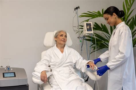 Nurse Checking Oxygen Level Through Oximeter For Senior Female Patient