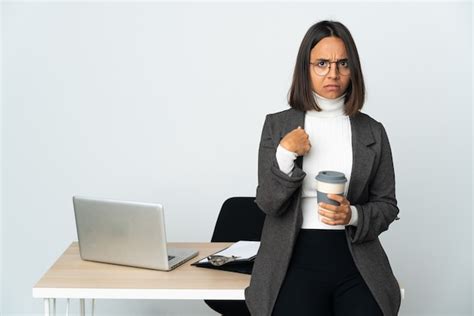 Mujer De Negocios Latina Joven Que Trabaja En Una Oficina Aislada En La Pared Blanca Apuntando A