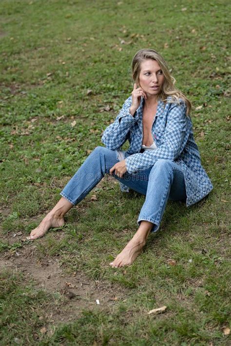 Blonde Beauty Basks In Late Summer Sunlight Exuding Elegance Amidst Lush Greenery Stock Image