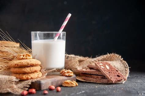 Vista Frontal De Una Leche Fresca En Un Vaso Picos De Galletas En Una Toalla De Color Nude