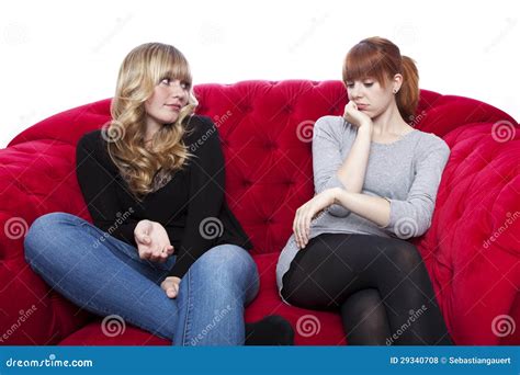 Junge Schöne Blonde Und Rote Behaarte Mädchen Auf Rotem Sofa Werden Gebohrt Stockfoto Bild von