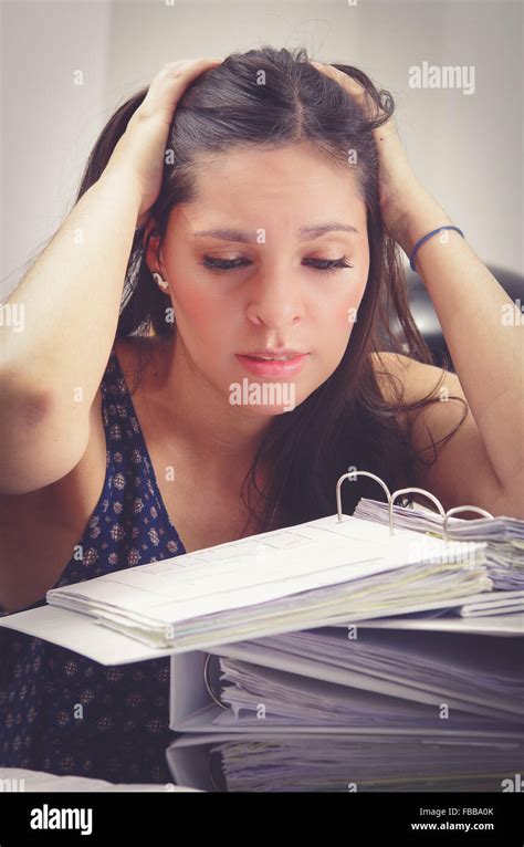 Hispanic Brunette Office Woman Working Sitting By Desk With Paper File Archive Open And Looking