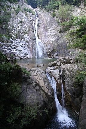 There Is A Small Waterfall In The Middle Of Some Rocks