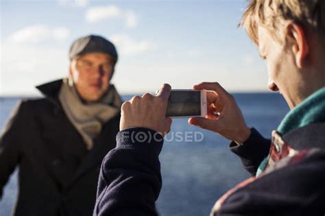 Man Photographing Gay Partner Sea Nature Stock Photo