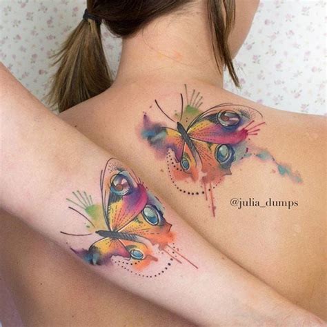 Two Colorful Butterflies On The Back Of A Womans Upper Half Sleeved Body