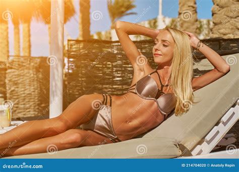 Sexy Femme Portant Bikini Assis Sur La Chaise Longue Sous Le Parapluie De La Canopée De Paille à