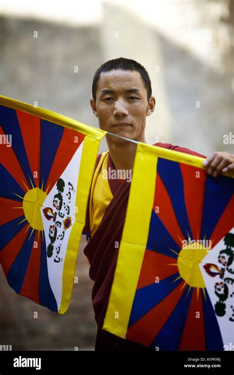 Portrait Of A Tibetan Buddhist Monk Holding Two Tibetan Flags Stock