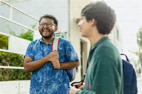 Foto Dos Hombres Parados Uno Al Lado Del Otro Hablando Universidad Imagen En Unsplash