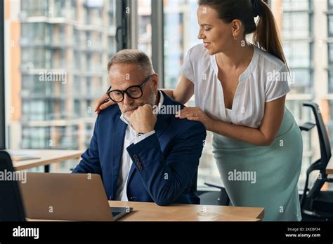 Female Assistant Doing Massage For Mature Boss In Offie Stock Photo Alamy