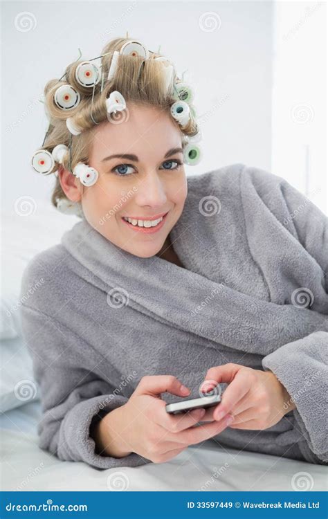 Joyful Relaxed Blonde Woman In Hair Curlers Using Her Mobile Phone Stock Image Image Of House