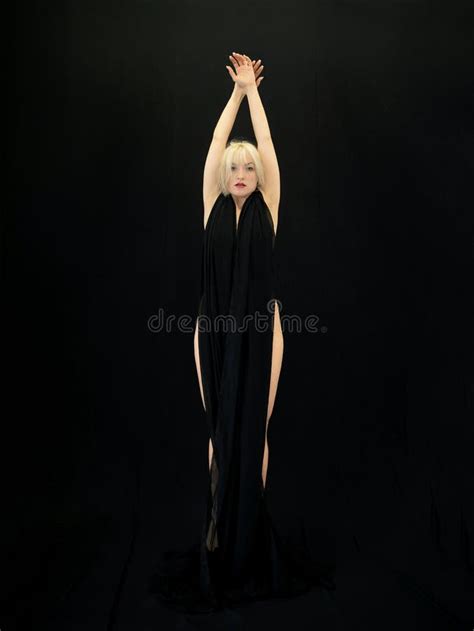 Standing Stretched Female Blonde Beauty Model Girl Hung With Black Fabric On Black Background