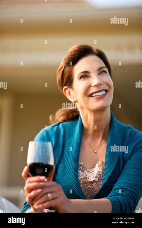 Mature Woman Enjoys Glass Of Red Wine In Her Backyard Stock Photo Alamy