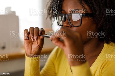 Young Woman Fidgeting A Pen And Reading Data Off The Computer Screen At