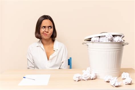 Joven mujer latina que parece perpleja y confundida preguntándose o tratando de resolver un