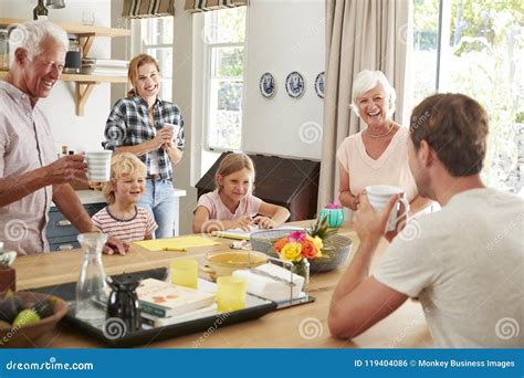 Familia Multi De La Generación Que Habla En Casa En Su Cocina Foto de