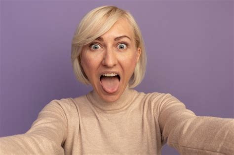 Excité Jolie Femme Slave Blonde Sort La Langue Et Fait Semblant De Tenir La Caméra Sur Le Violet