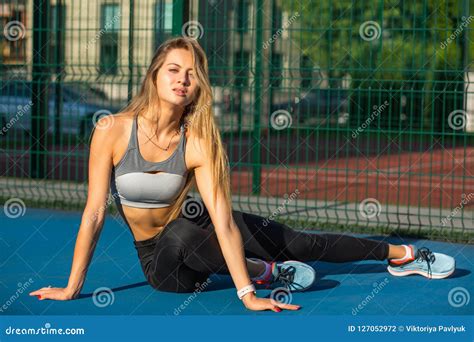 Slender Blonde Model With Perfect Body Wearing Sport Apparel Posing Near The Fence At The Tennis
