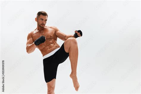 Man Athletic Bodybuilder Poses In Boxing Gloves With Nude Torso Abs In Full Length Background
