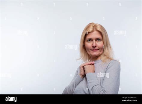 Attractive Mature Blonde Woman Wearing A Gray Turtleneck Looking At The Camera Stock Photo Alamy