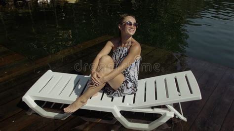 Woman Sit On A Sunbed In Sunglasses And Swimming Suit Girl Rest On A