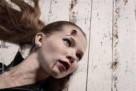 Stock-Foto „Hit woman. Woman in a latex suit killed in gunfire shot in