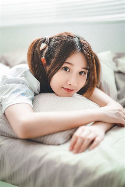 Asian Women Model Women Indoors Brunette Dyed Hair Face Lying On Front In Bed Looking