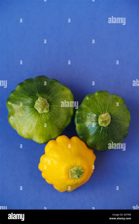 Yellow And Green Pattypan Squash On A Blue Background Stock Photo Alamy