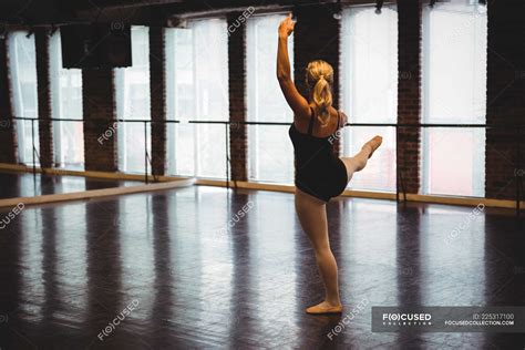 Ballerina performing ballet dance move in ballet studio — bar ...