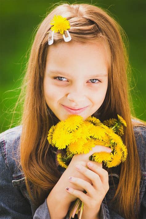 Portrait De La Jeune Fille De Sourire Tenant Le Bouquet Des Fleurs En