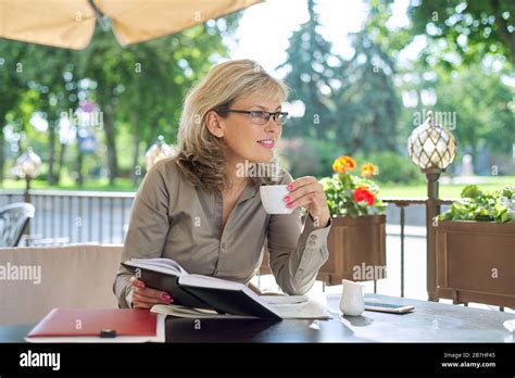 Beautiful Mature Business Woman Drinking Coffee At Break In Outdoor Restaurant Smiling Blonde