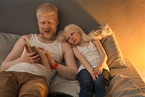 Homme Allong Au Lit Avec Sa Petite Fille Blonde Et Livre De Lecture Pour Elle Photo Stock