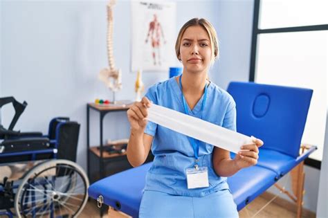 Jeune Femme Blonde Tenant Une Bande De Th Rapie Sceptique Et Nerveuse Fron Ant Les Sourcils